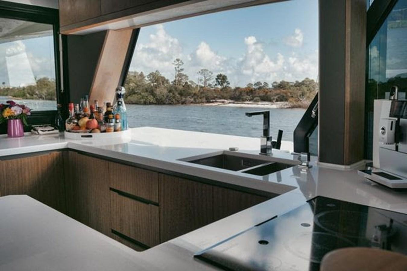 a kitchen with a large window aboard JUST IN TIME Yacht for Sale