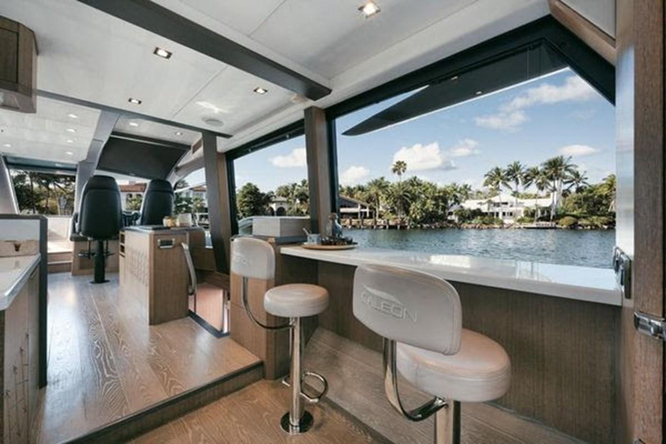 a room with a table chairs and a large window with a view of the ocean aboard JUST IN TIME Yacht for Sale