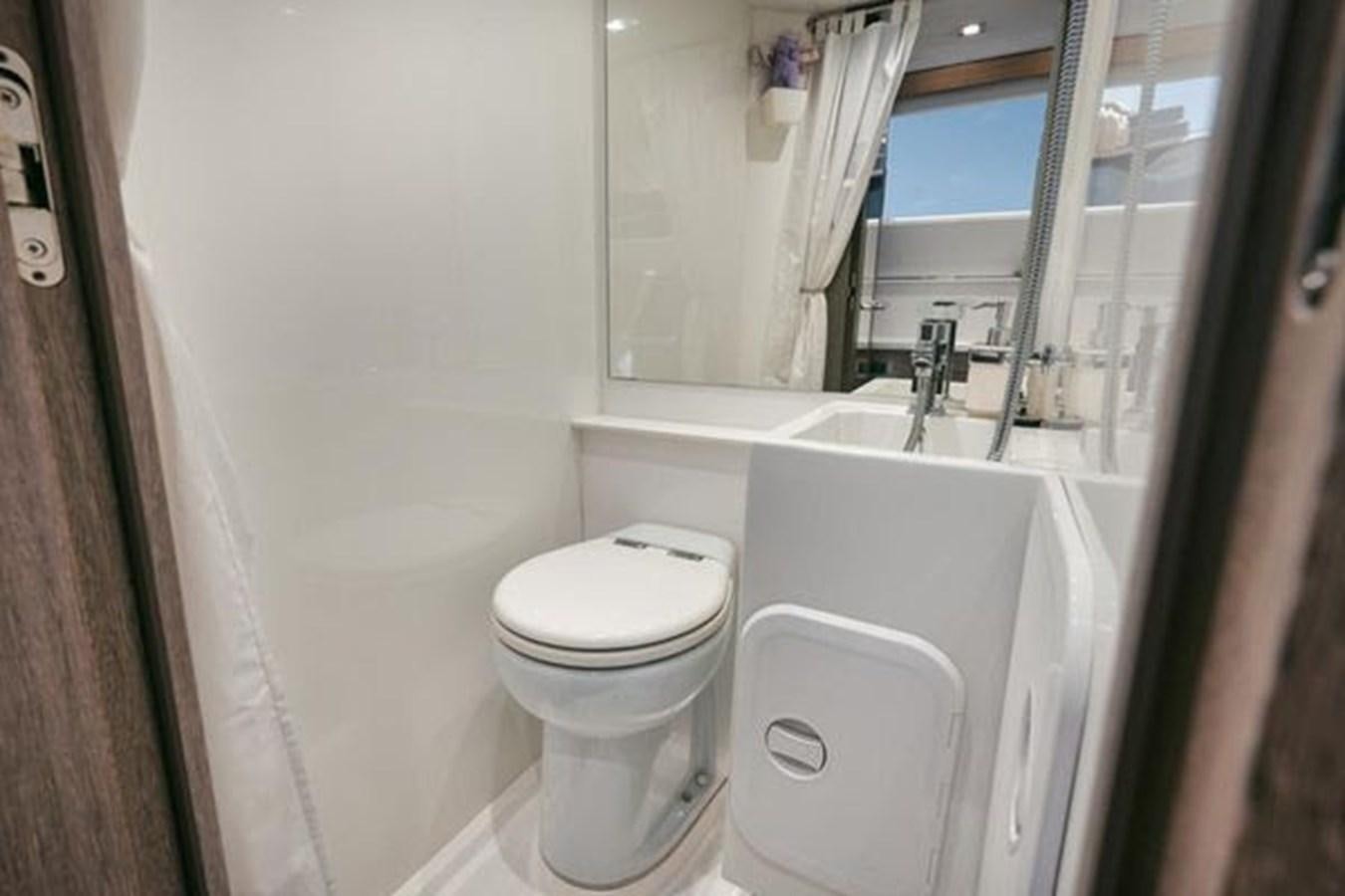 a bathroom with a toilet and bathtub aboard JUST IN TIME Yacht for Sale