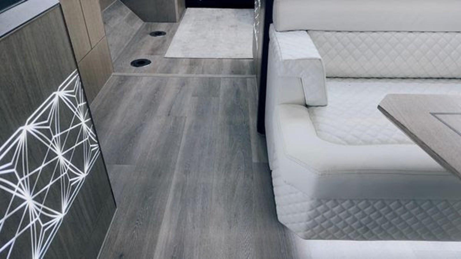a wood floor with a couch and a rug on it aboard JUST IN TIME Yacht for Sale