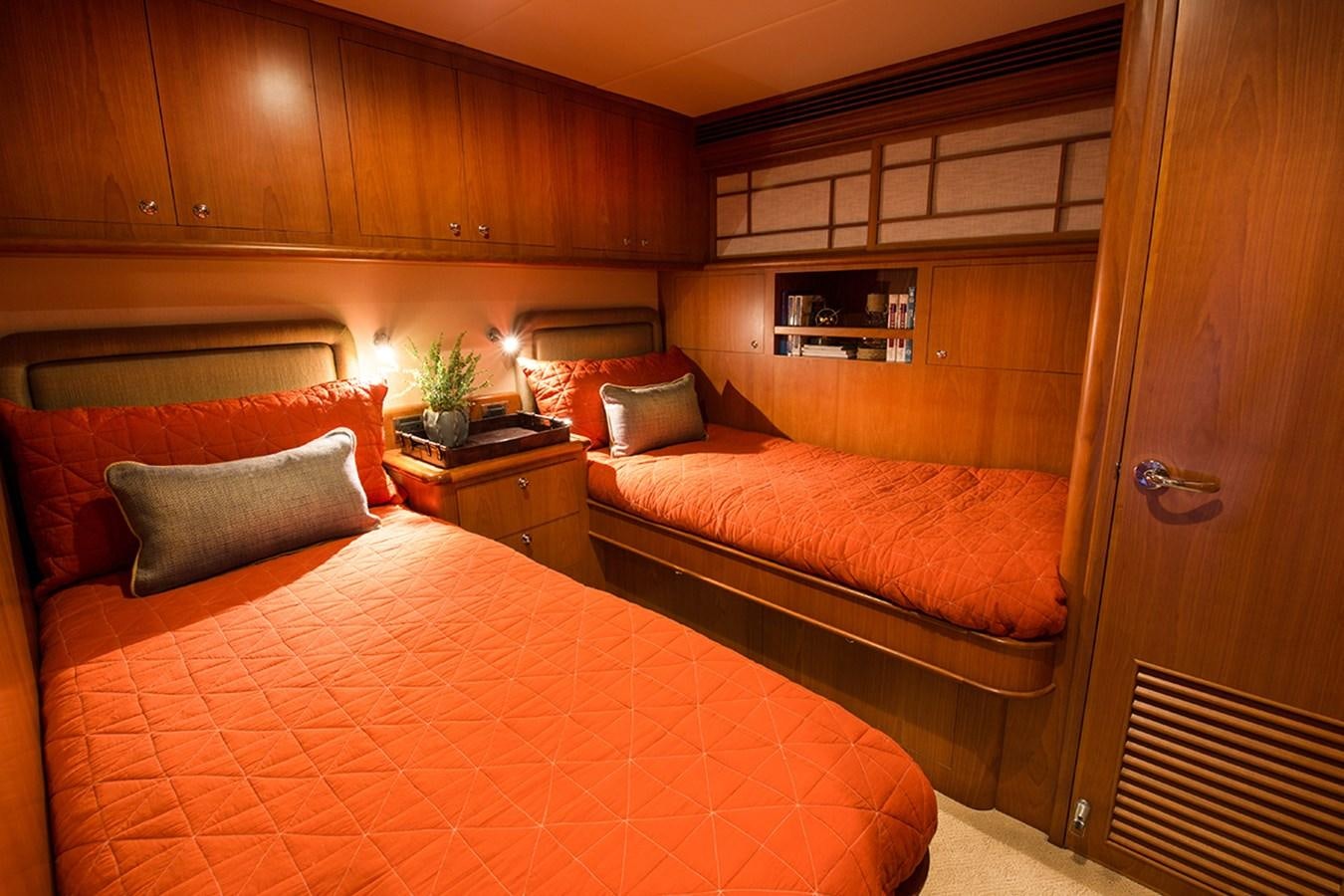 a bedroom with a bed and a wood cabinet aboard 44 NORTH Yacht for Sale