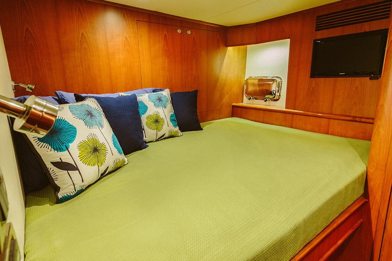 a bed with blue and white pillows aboard 44 NORTH Yacht for Sale
