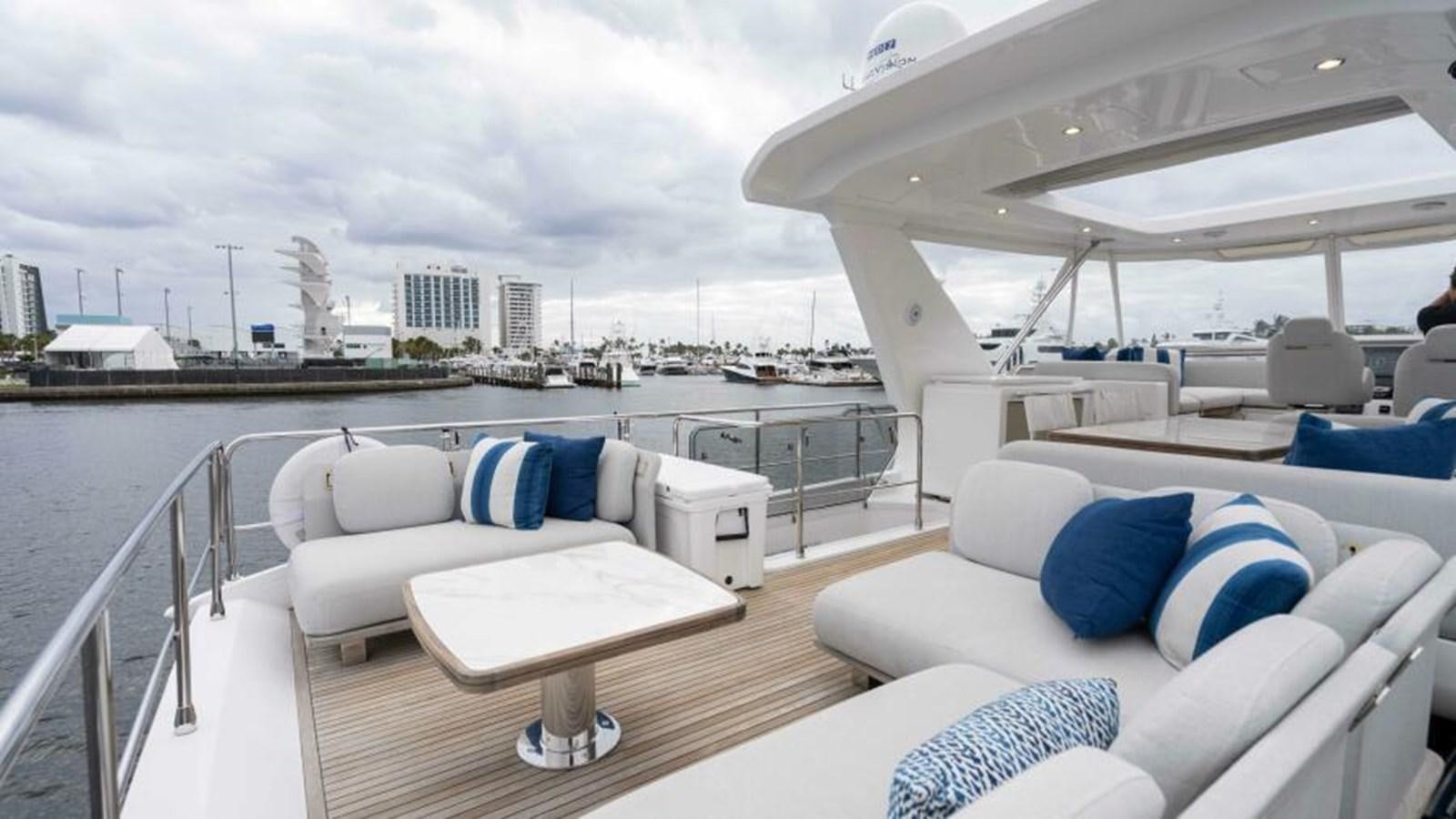 a large white lounge chair on a deck with a city skyline in the background aboard LIQUID ASSET Yacht for Sale