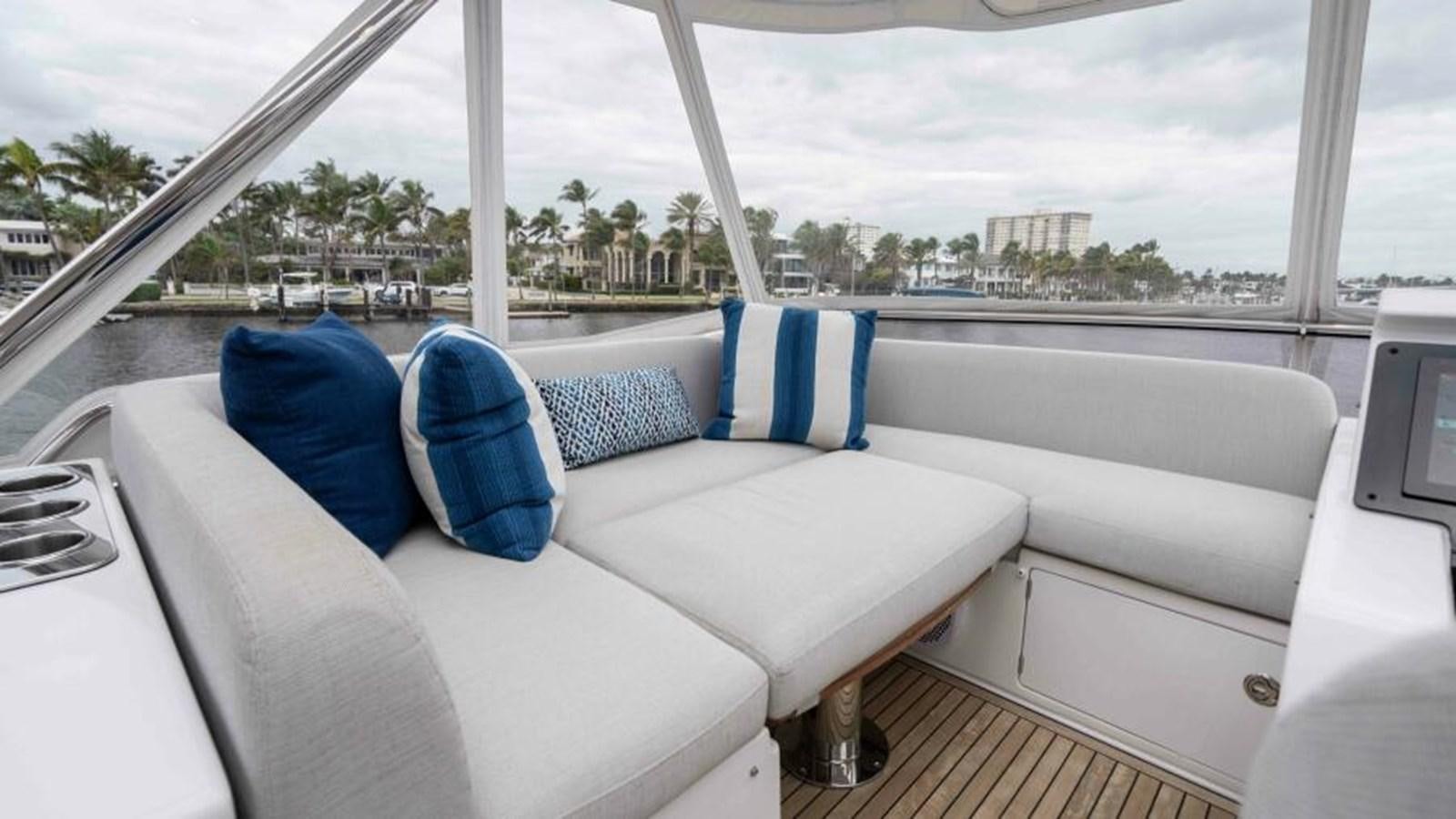 a white couch with blue pillows on it aboard LIQUID ASSET Yacht for Sale