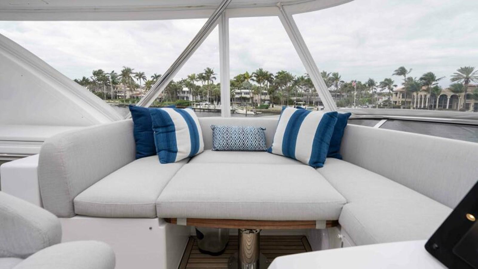 a white couch with blue pillows aboard LIQUID ASSET Yacht for Sale