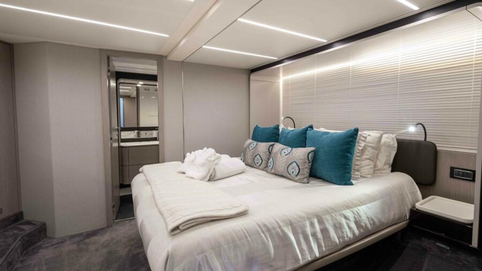 a bedroom with a bed and a chair aboard LIQUID ASSET Yacht for Sale
