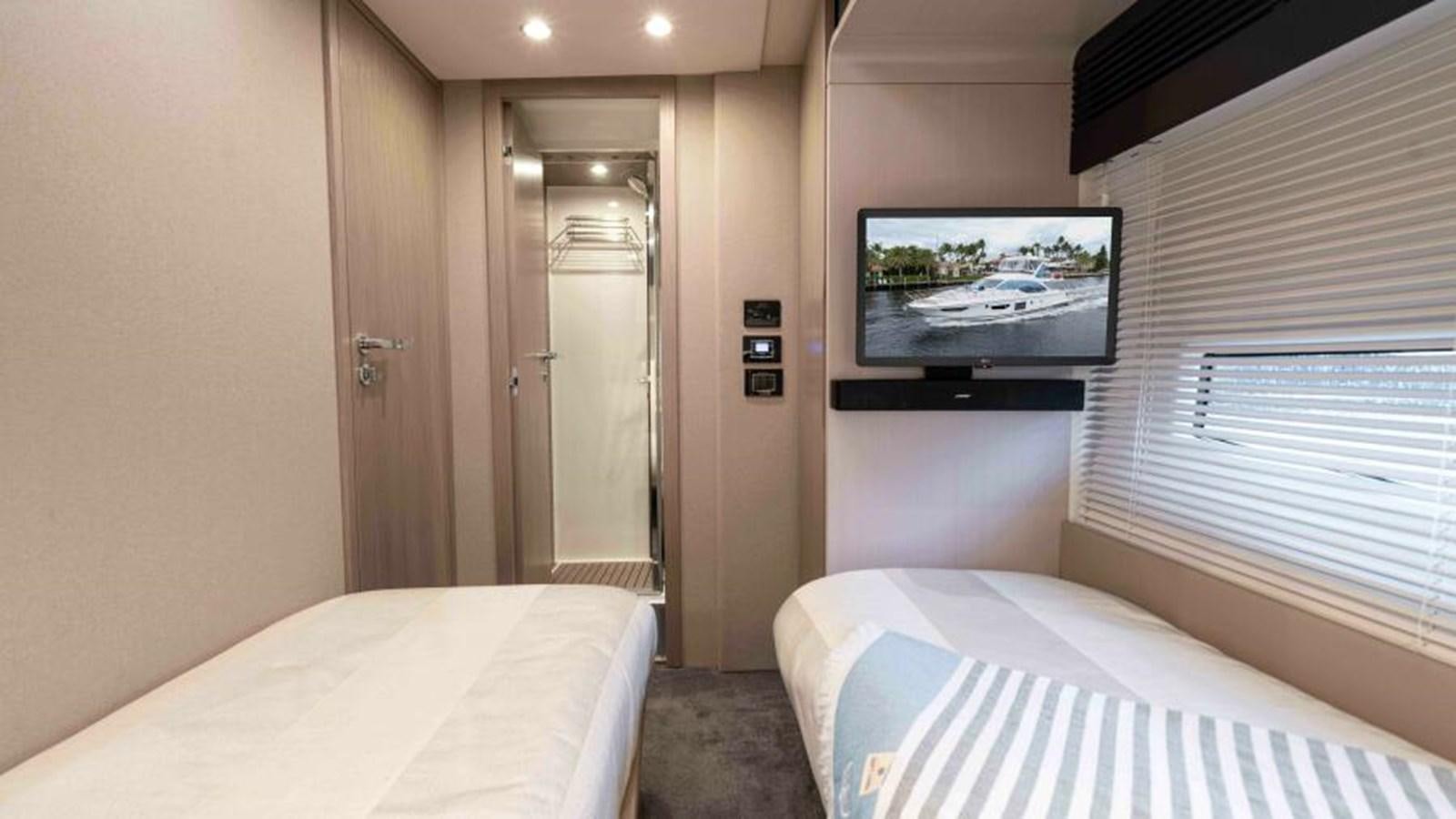 a bedroom with a tv and a bed aboard LIQUID ASSET Yacht for Sale