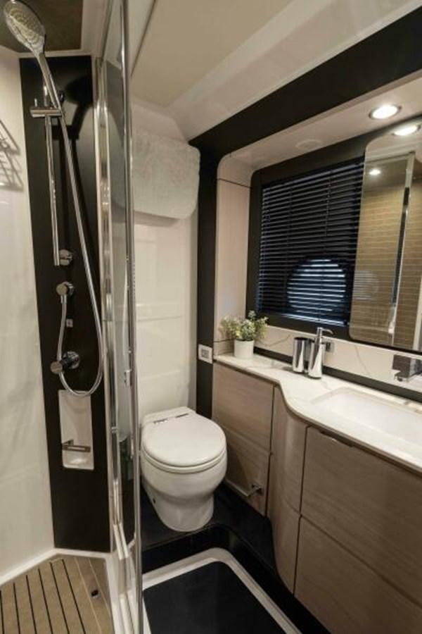 a bathroom with a toilet and a sink aboard LIQUID ASSET Yacht for Sale