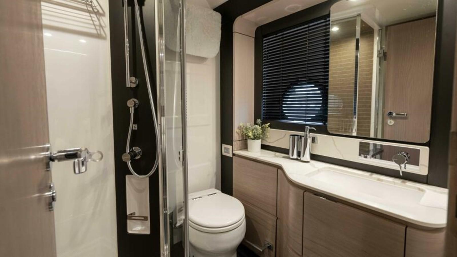 a bathroom with a toilet and a sink aboard LIQUID ASSET Yacht for Sale