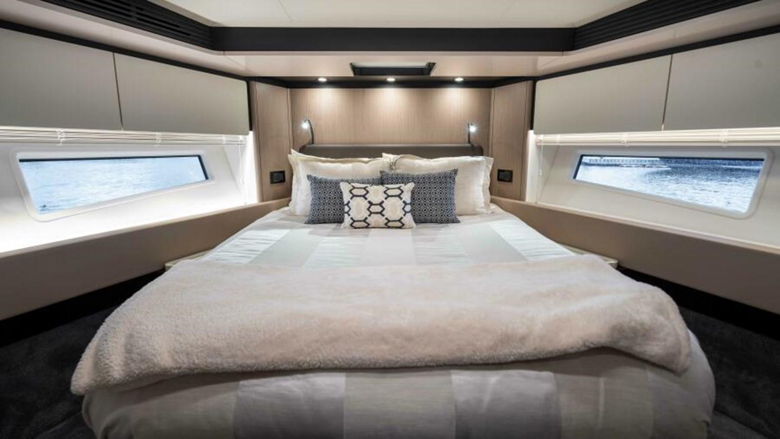 a bed with a white sheet and pillows aboard LIQUID ASSET Yacht for Sale