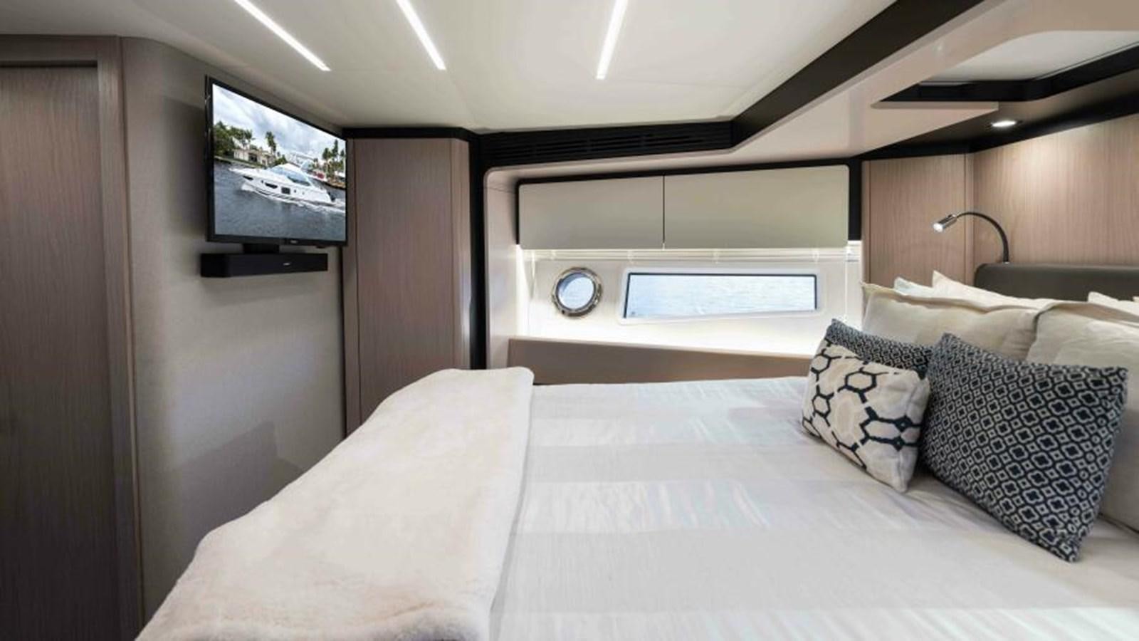 a bed with pillows and a television aboard LIQUID ASSET Yacht for Sale