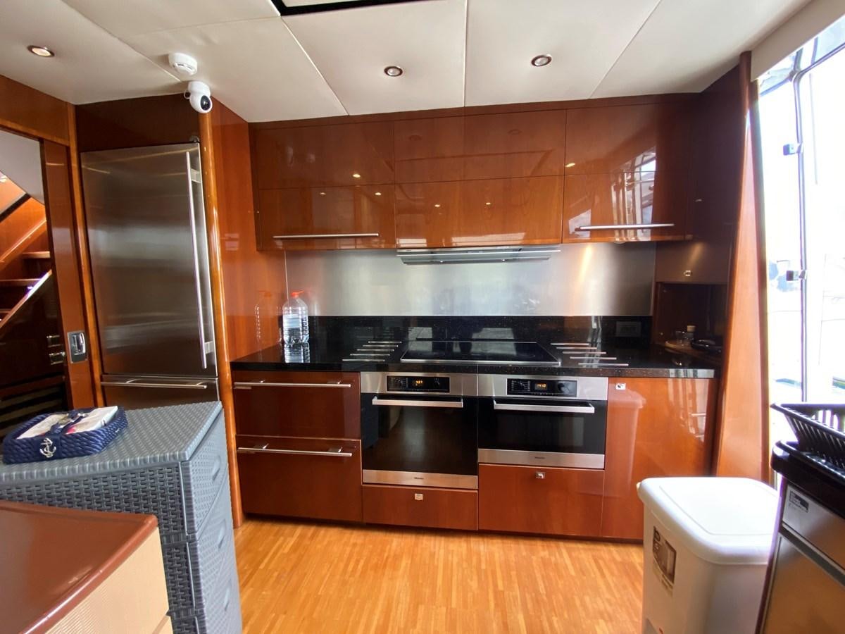 a kitchen with wooden cabinets aboard 95 MY Yacht for Sale
