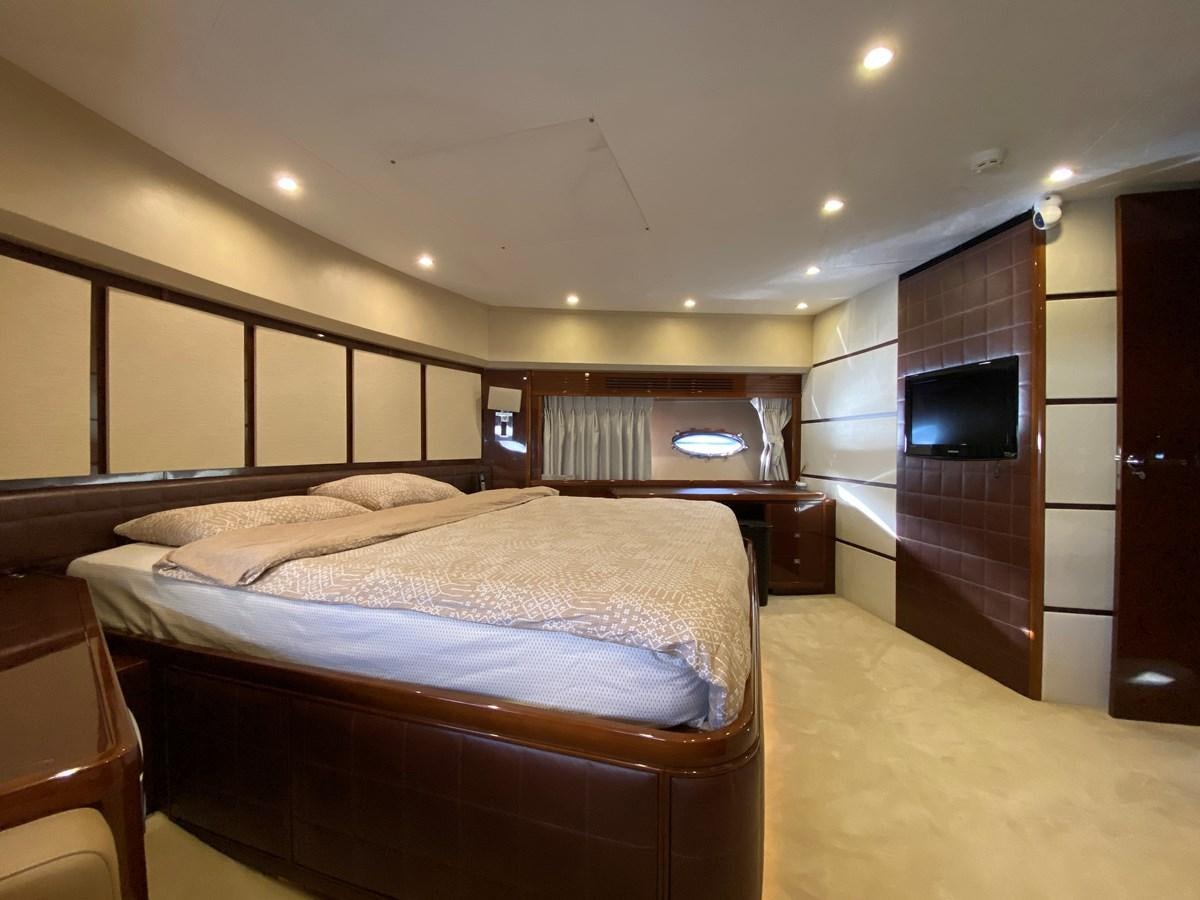 a bedroom with a bed and a television aboard 95 MY Yacht for Sale