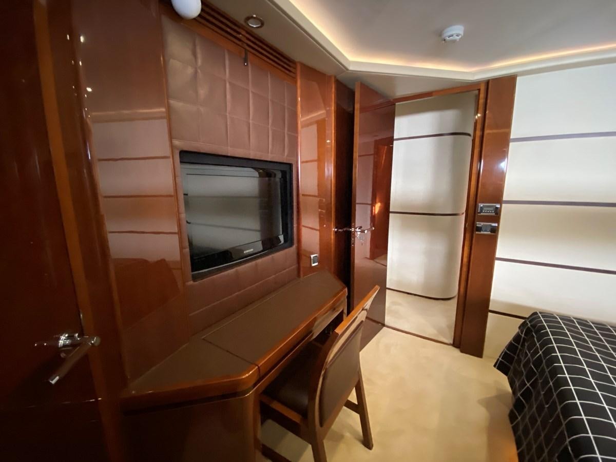a room with a bed and a television aboard 95 MY Yacht for Sale