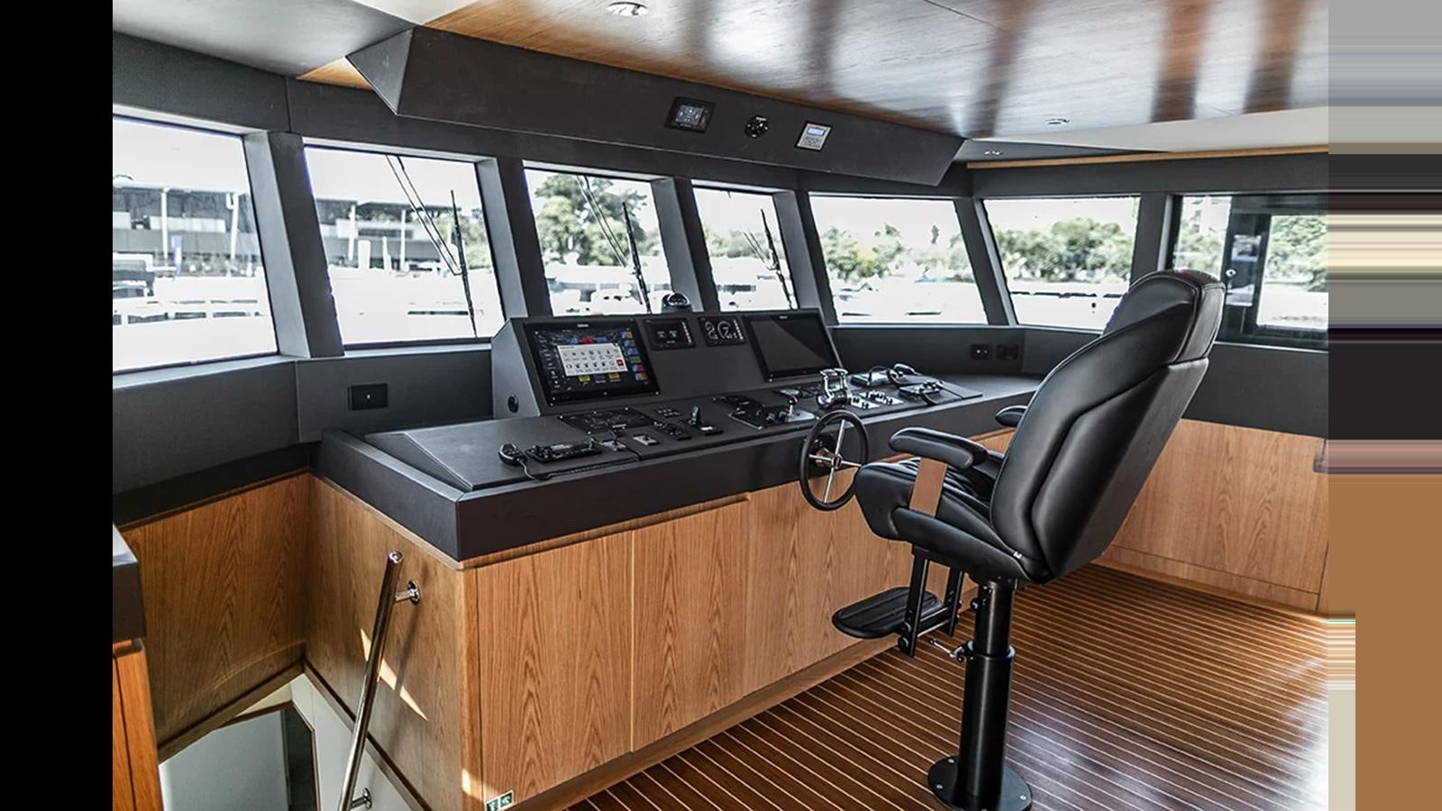 a black chair in front of a computer desk in a room with many windows aboard 2024 INACE EXPLORA 115 Yacht for Sale