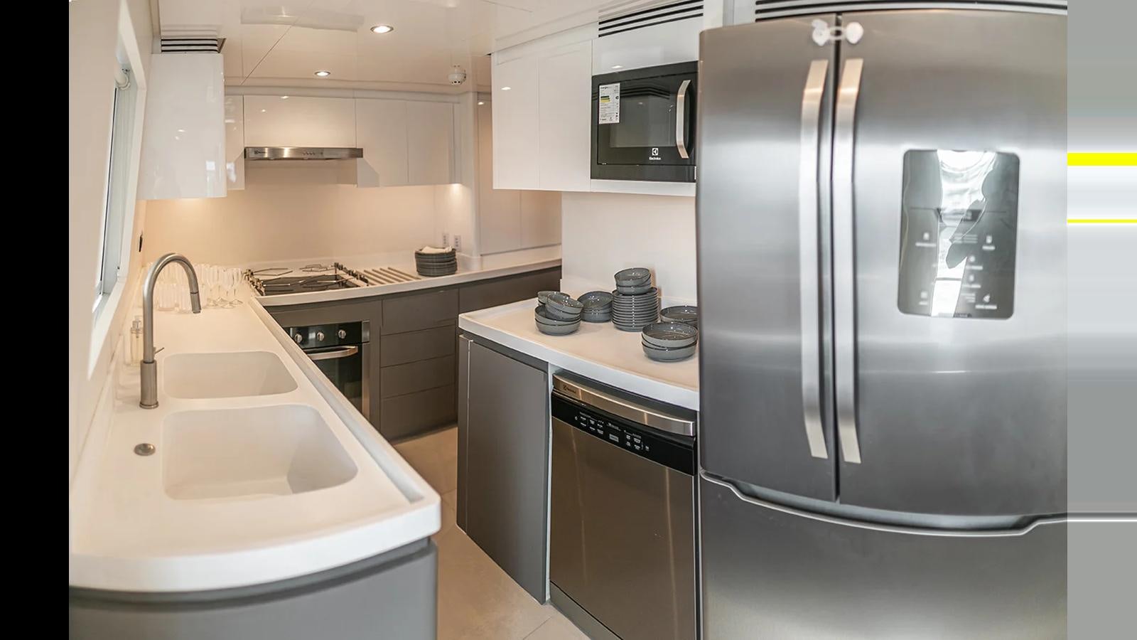 a kitchen with a stainless steel refrigerator aboard 2024 INACE EXPLORA 115 Yacht for Sale