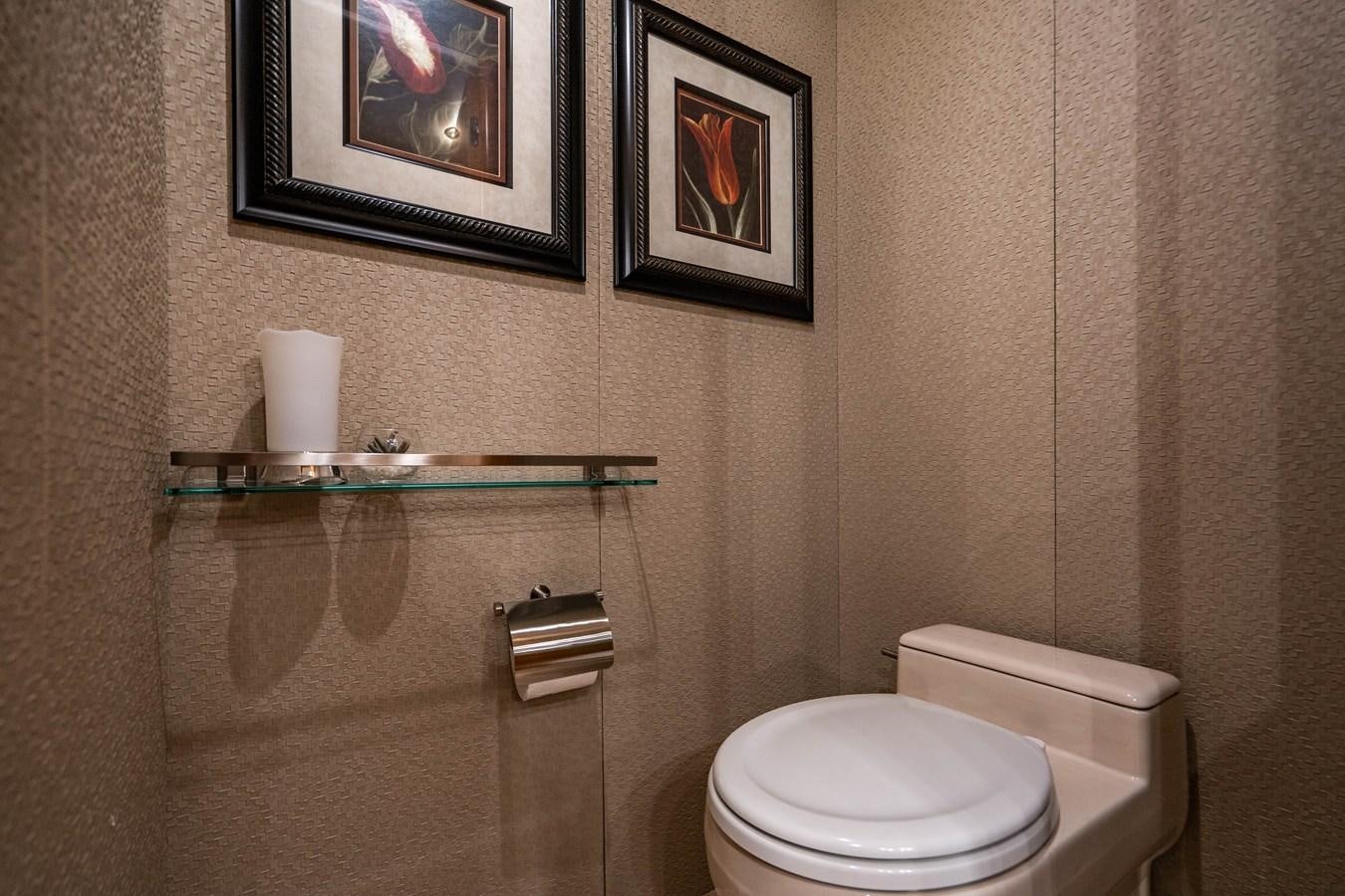 a bathroom with a toilet and a picture on the wall aboard VOYAGER Yacht for Sale