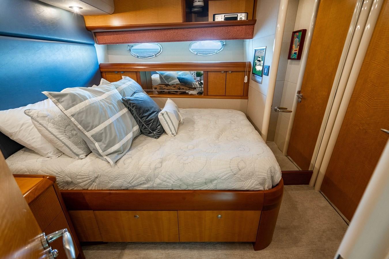 a bed with a wooden headboard aboard VOYAGER Yacht for Sale