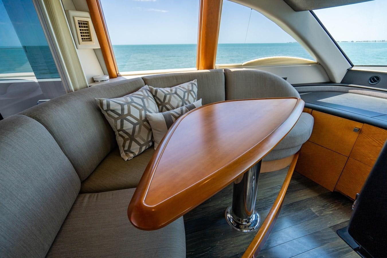 a couch and a table in a room with a body of water in the background aboard VOYAGER Yacht for Sale
