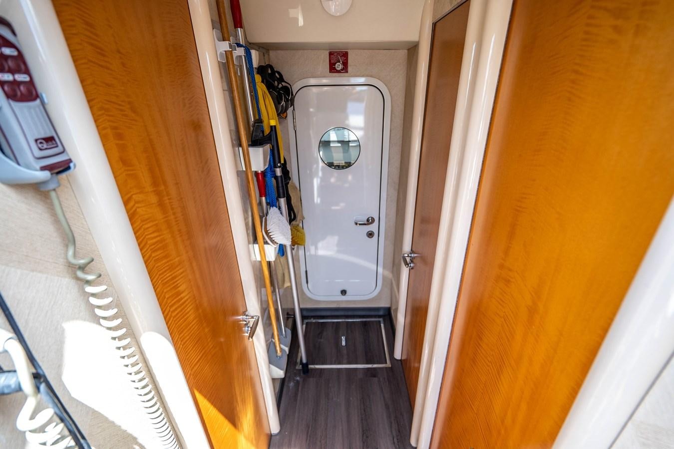 a hallway with a white door and a metal railing aboard VOYAGER Yacht for Sale