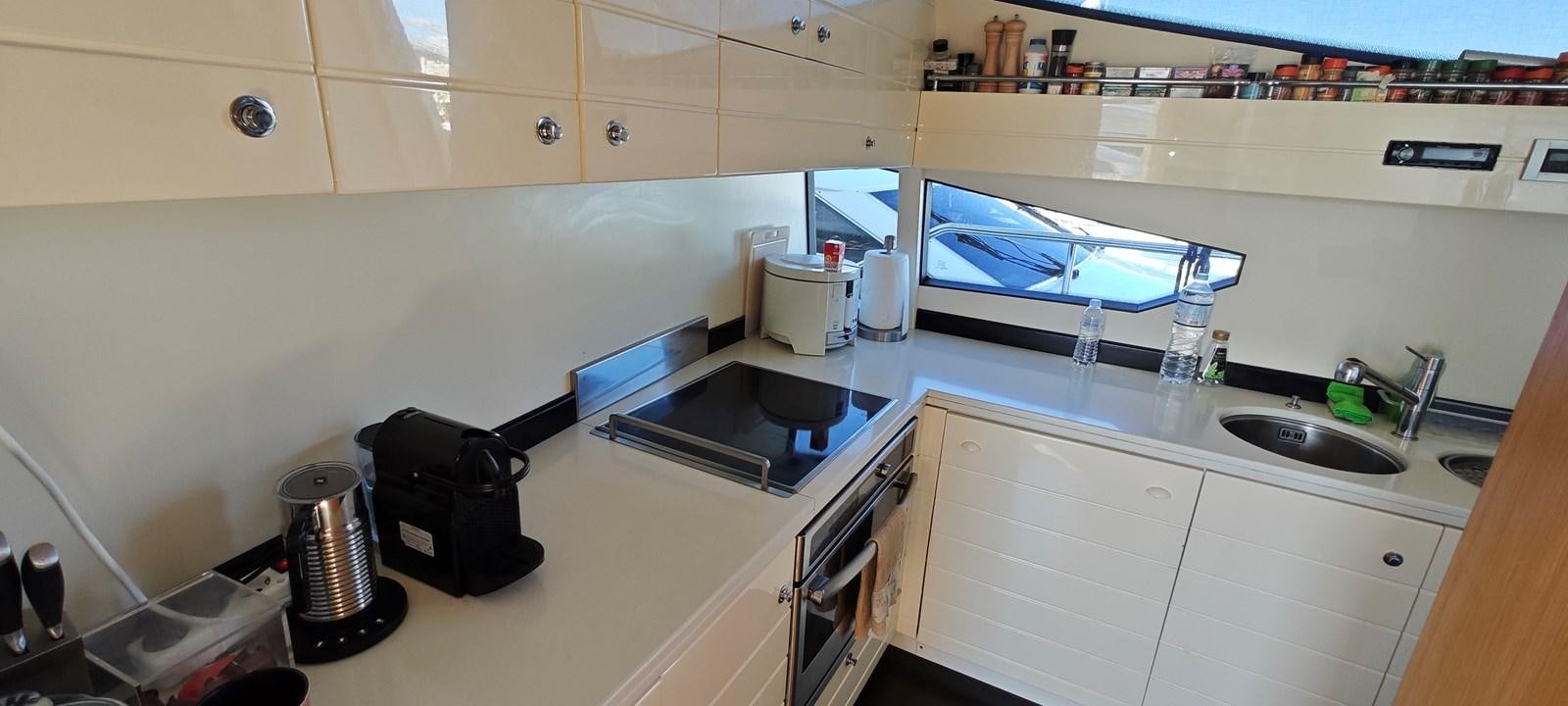a kitchen with a tv and a sink aboard MAYBE NOT Yacht for Sale