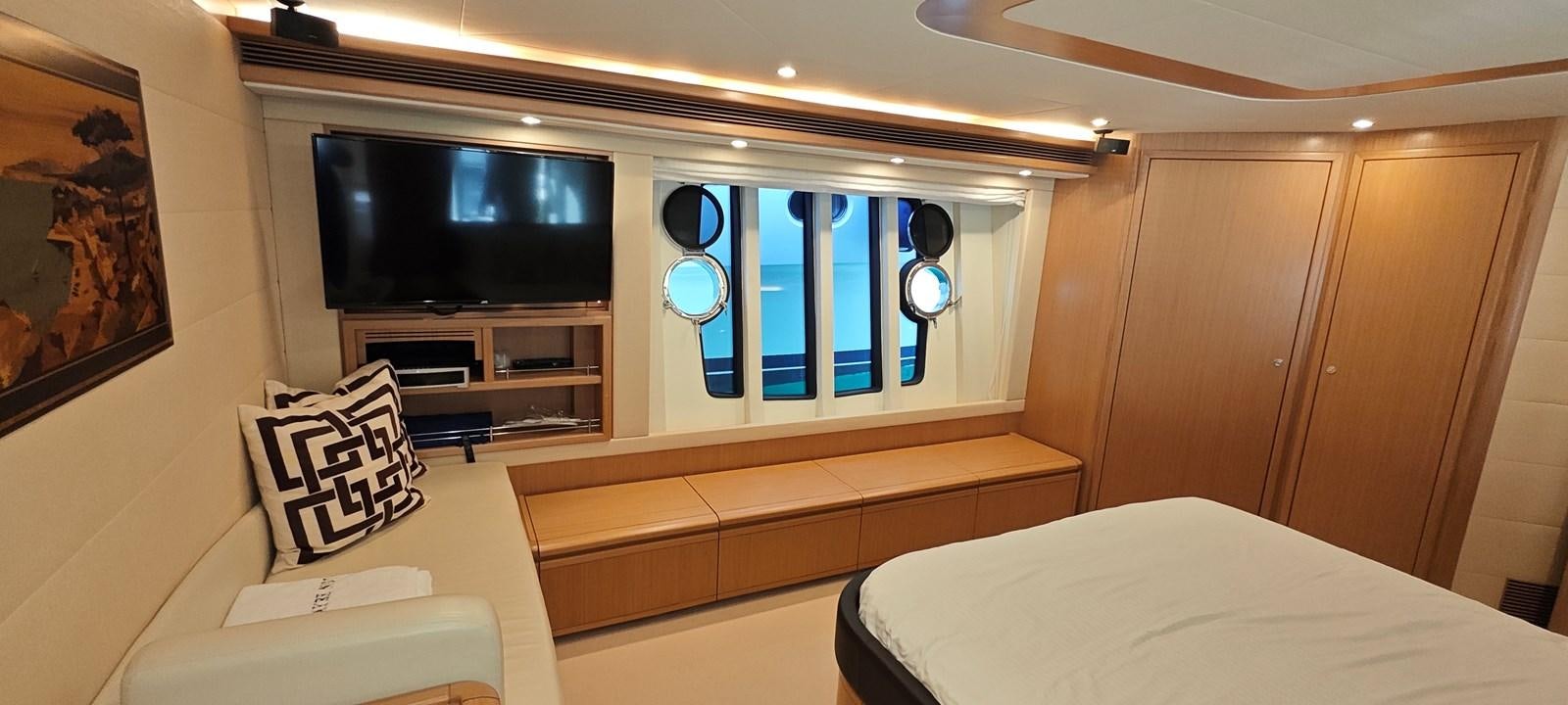 a room with a bed and a tv on the wall aboard MAYBE NOT Yacht for Sale