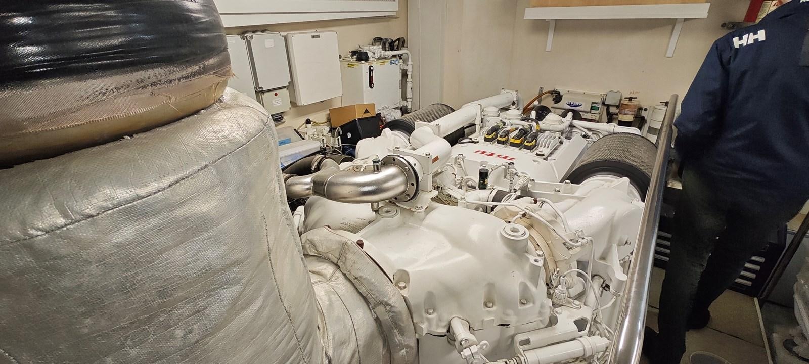 a person in a blue jacket standing next to a white car aboard MAYBE NOT Yacht for Sale