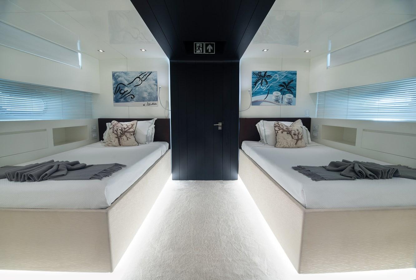 a room with beds and a door aboard XANAX Yacht for Sale