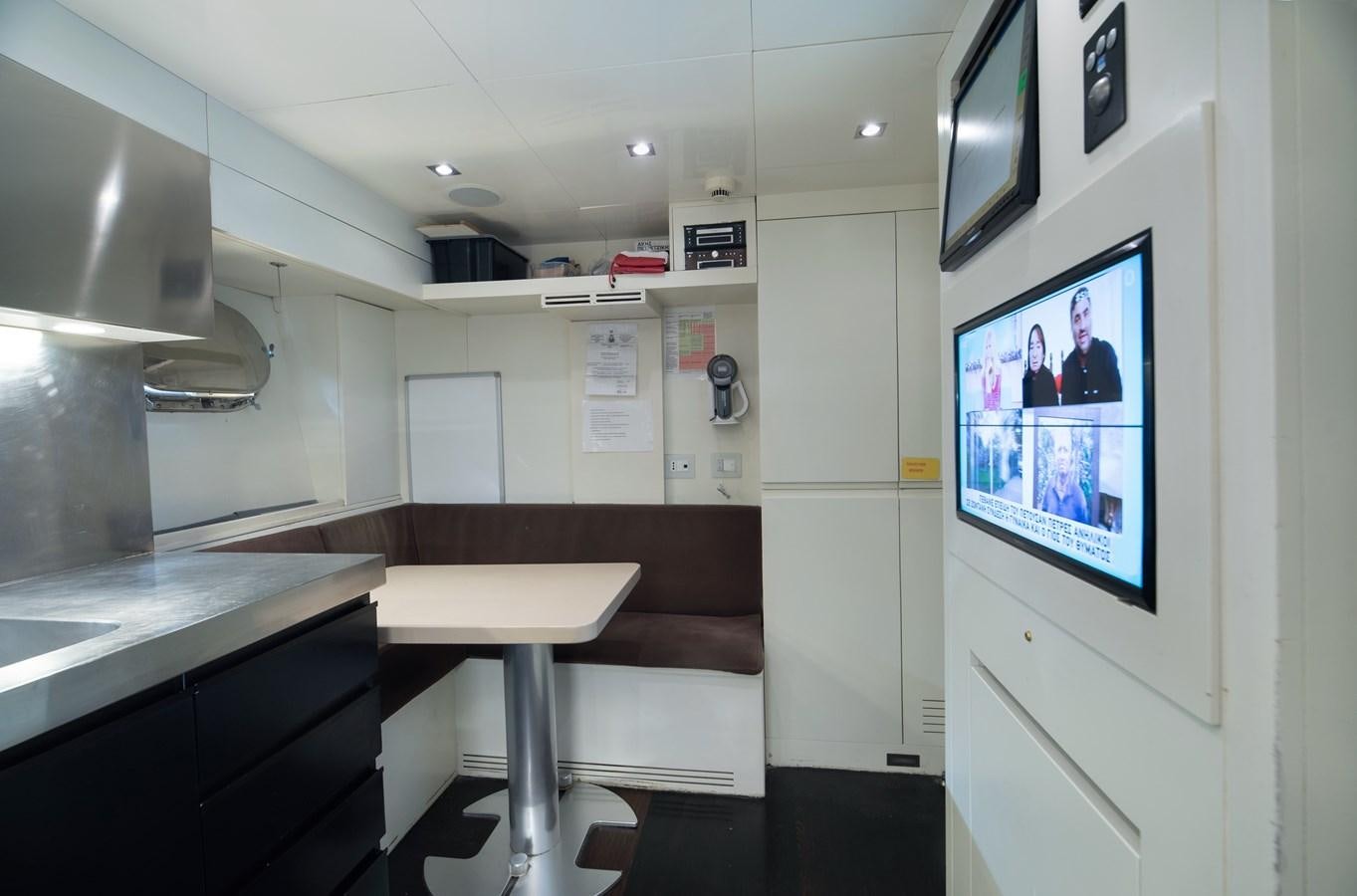 a room with a desk and a tv on the wall aboard XANAX Yacht for Sale