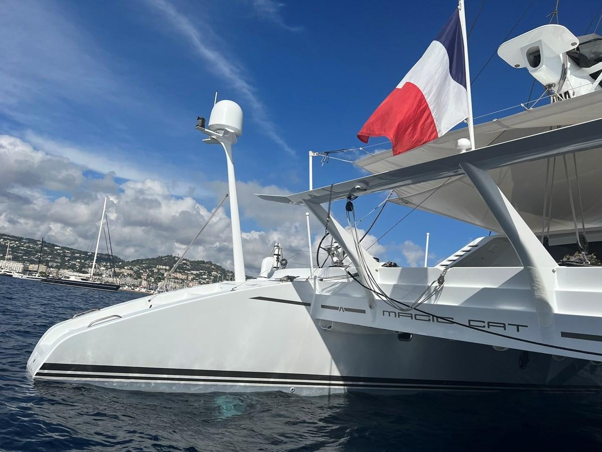 a boat with a flag on it aboard MAGIC CAT Yacht for Sale
