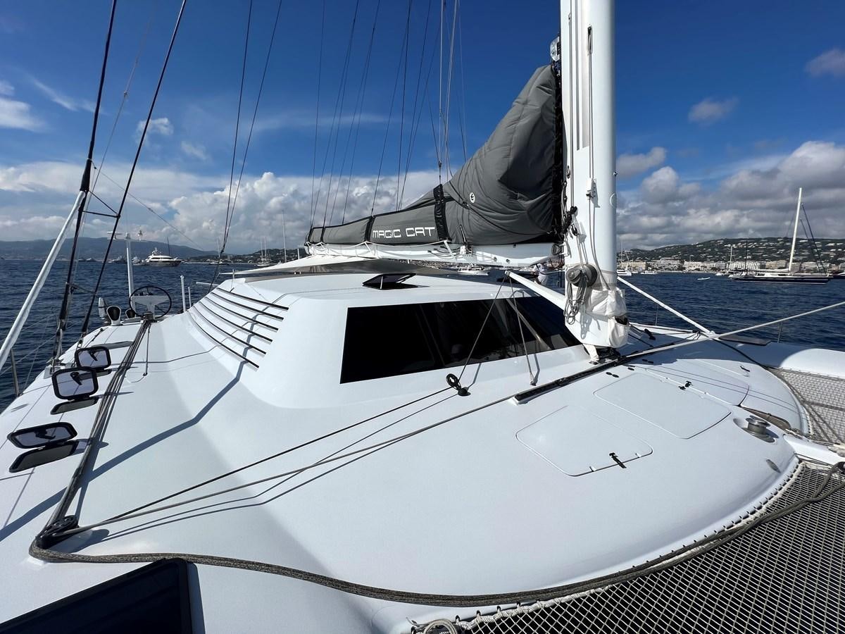 a white yacht in a harbor aboard MAGIC CAT Yacht for Sale