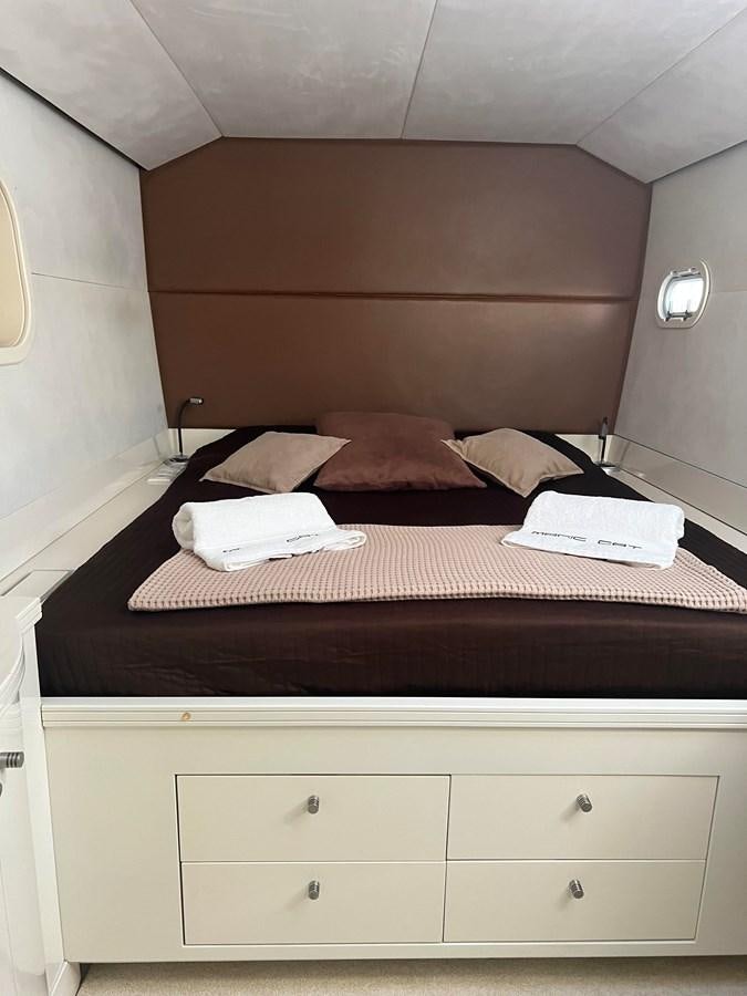 a bed with a wooden headboard aboard MAGIC CAT Yacht for Sale