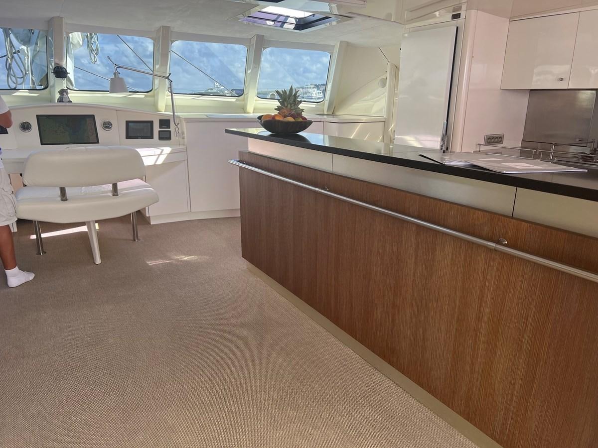 a kitchen with a counter and chairs aboard MAGIC CAT Yacht for Sale