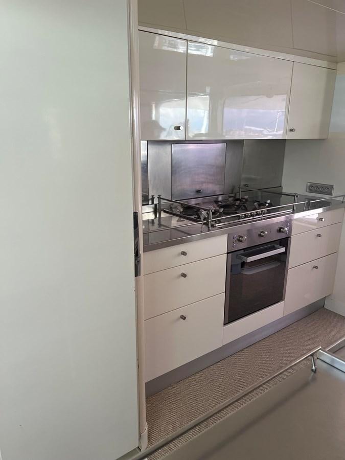 a kitchen with a stove and a microwave aboard MAGIC CAT Yacht for Sale