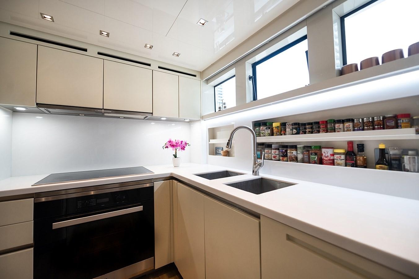 a kitchen with white cabinets aboard RYEN Yacht for Sale