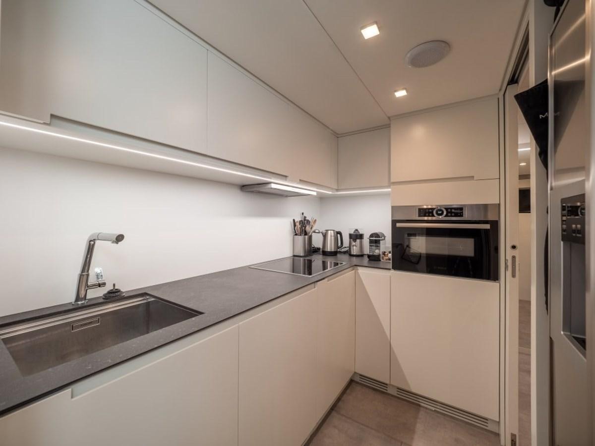 a kitchen with white cabinets aboard SURVIVOR Yacht for Sale
