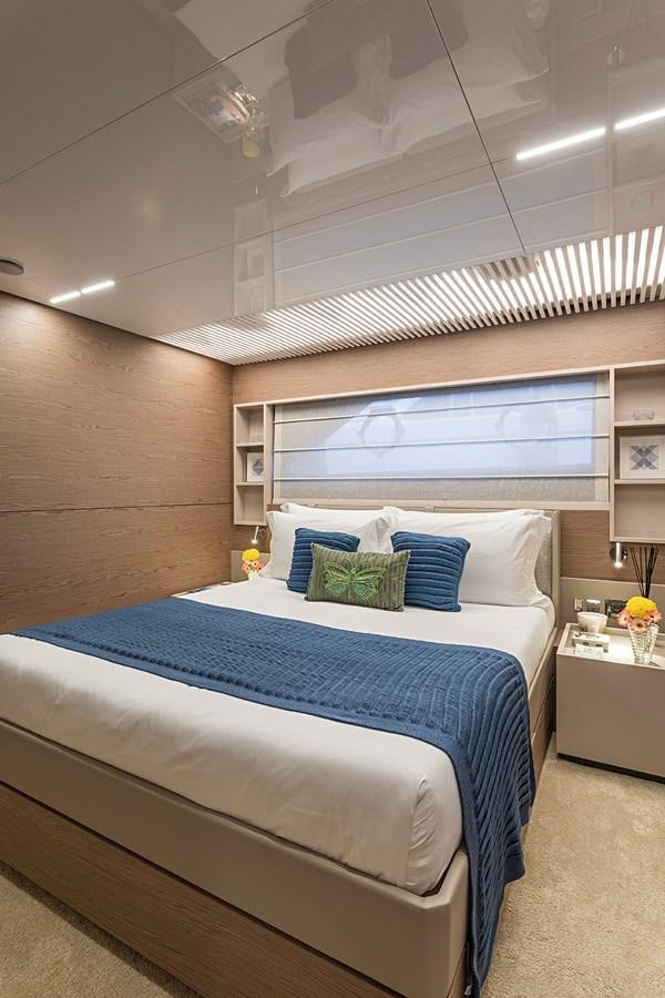 a bed with a blue and white bed spread aboard ANINHA 1 Yacht for Sale