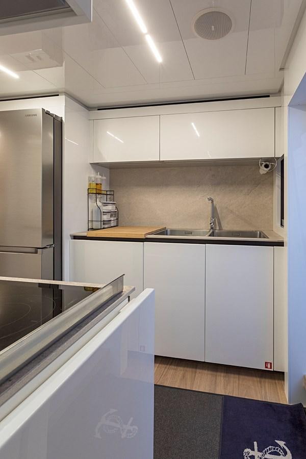 a kitchen with a stainless steel refrigerator aboard ANINHA 1 Yacht for Sale