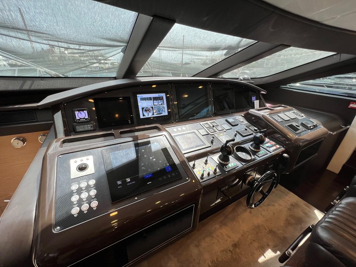 a wooden desk with a computer and other electronic devices on it aboard MANGUSTA MAXIOPEN 94#2 - MISS BUBBLES - CAREFULLY USED Yacht for Sale