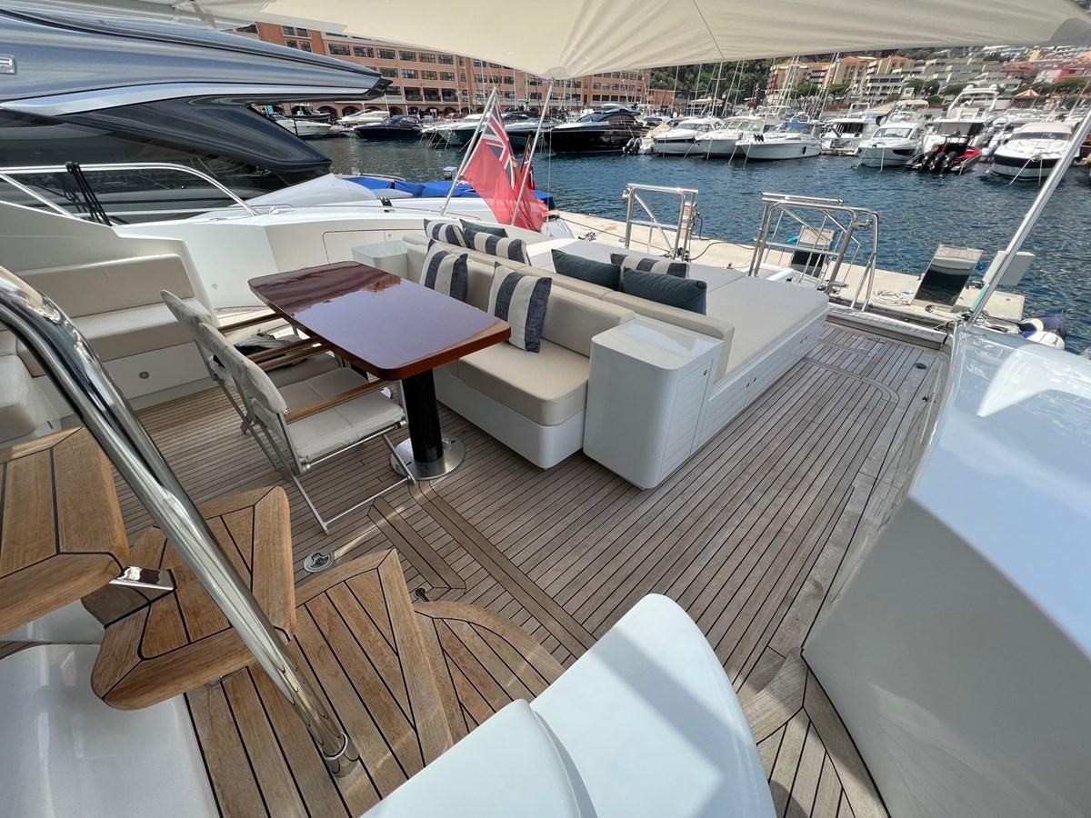 a deck with a table and chairs on it aboard MANGUSTA MAXIOPEN 94#2 - MISS BUBBLES - CAREFULLY USED Yacht for Sale