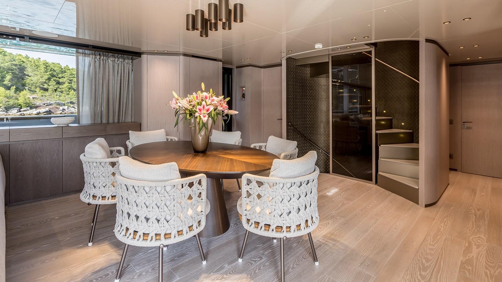 a room with a table chairs and a window aboard EROS Yacht for Sale