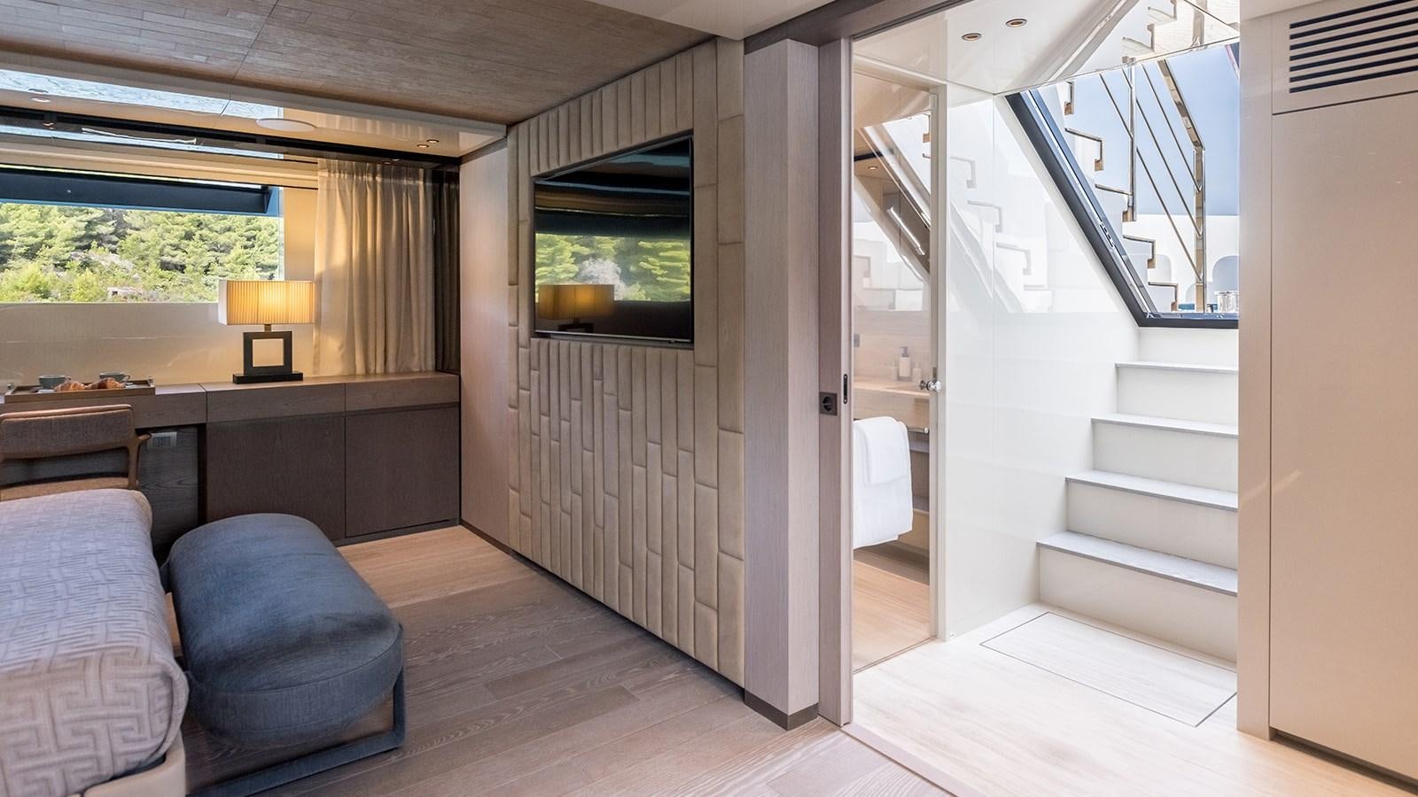 a living room with a couch and a staircase aboard EROS Yacht for Sale