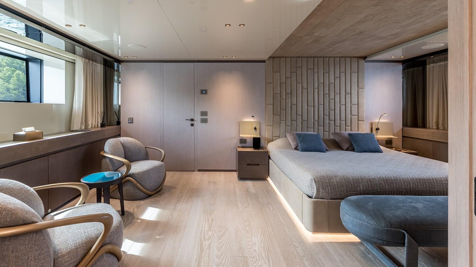 a bedroom with a bed and a chair aboard EROS Yacht for Sale