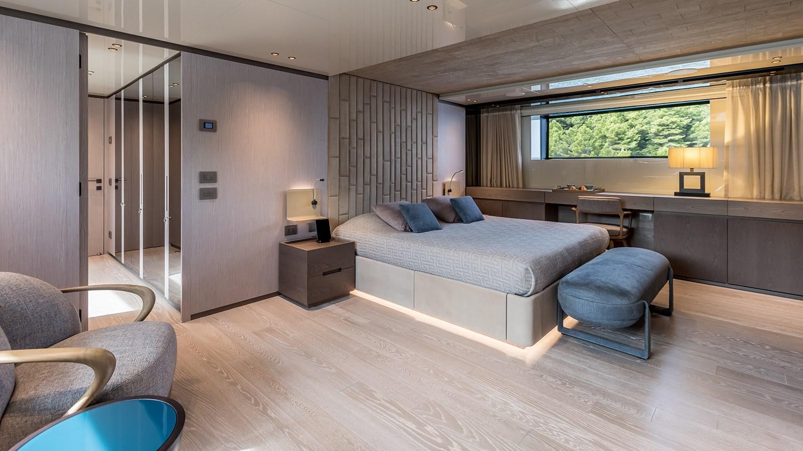 a large bedroom with a bed and a desk aboard EROS Yacht for Sale