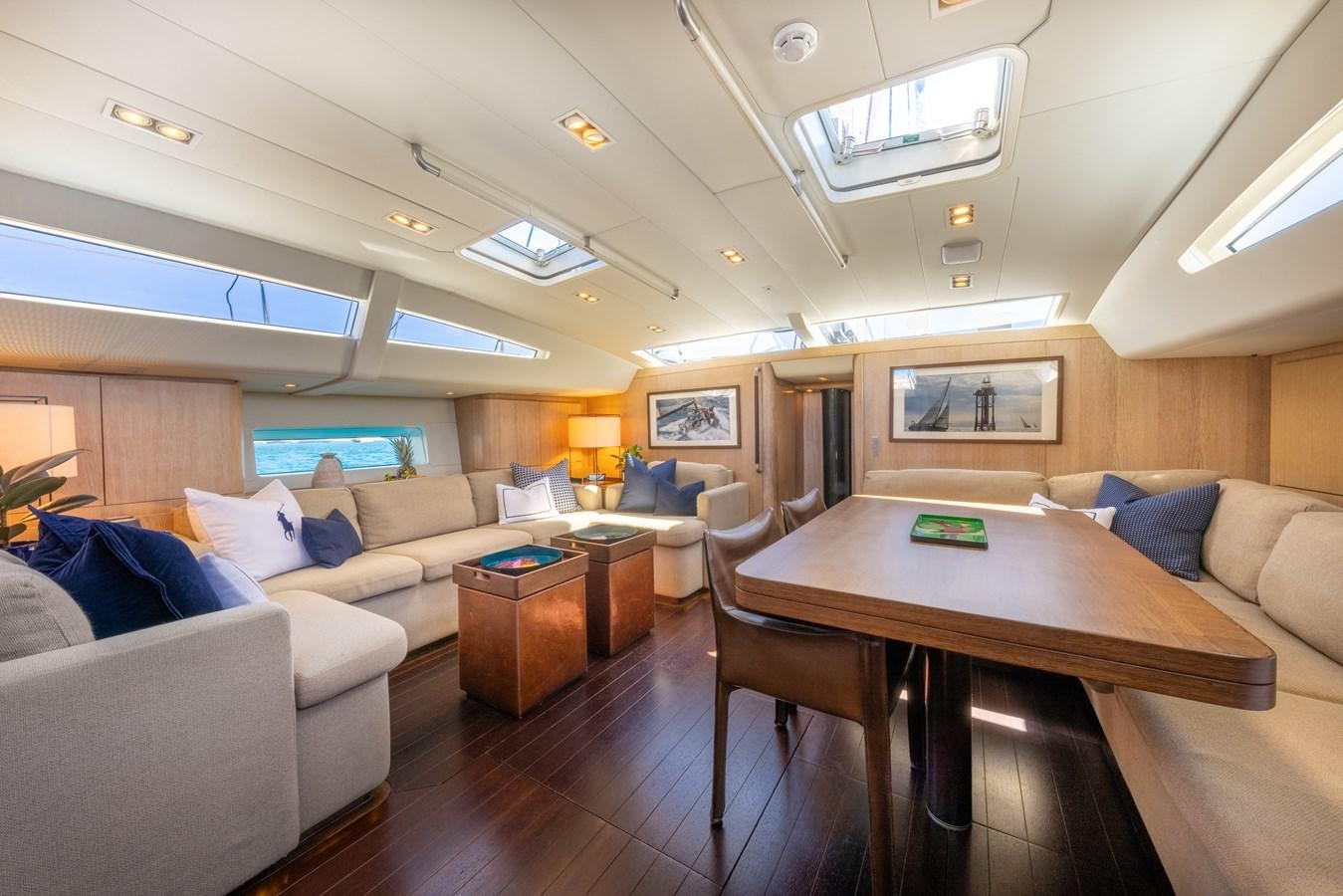 a living room with a table and couches aboard YCH2 Yacht for Sale
