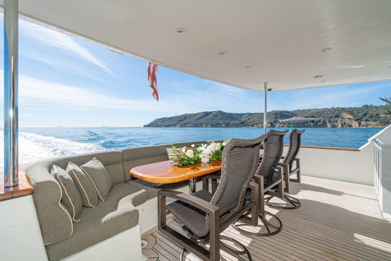 a table and chairs on a deck overlooking a body of water aboard BESAME Yacht for Sale