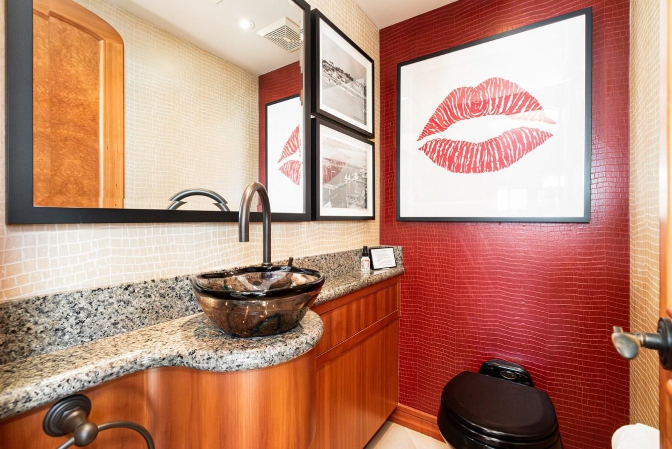 a bathroom with a sink and a painting on the wall aboard BESAME Yacht for Sale