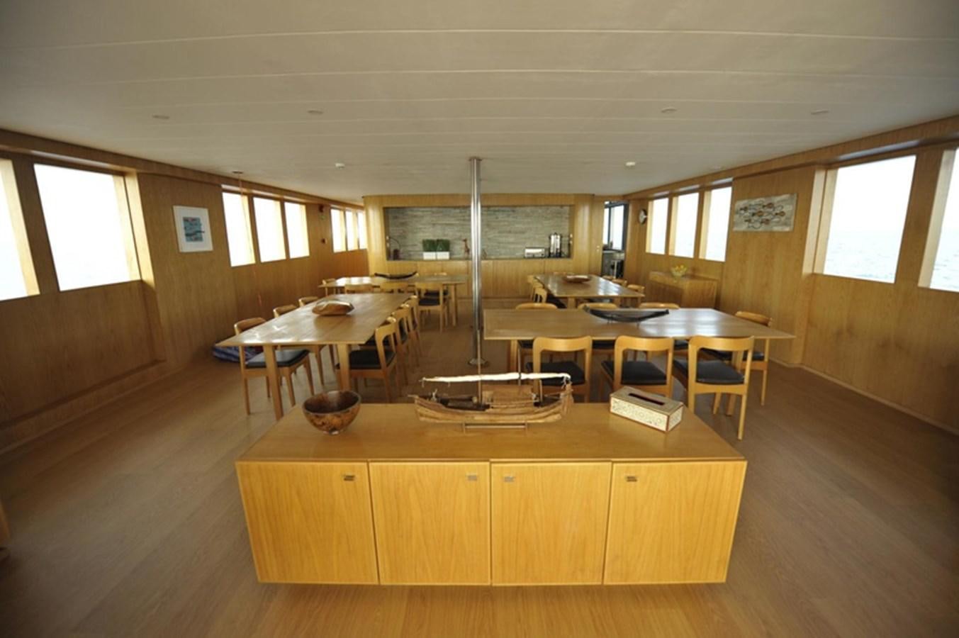 a room with tables and chairs aboard 2017 SAFARI  142 CUSTOM Yacht for Sale
