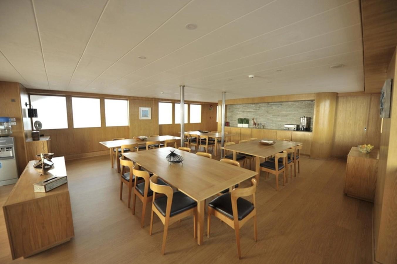 a room with tables and chairs aboard 2017 SAFARI  142 CUSTOM Yacht for Sale