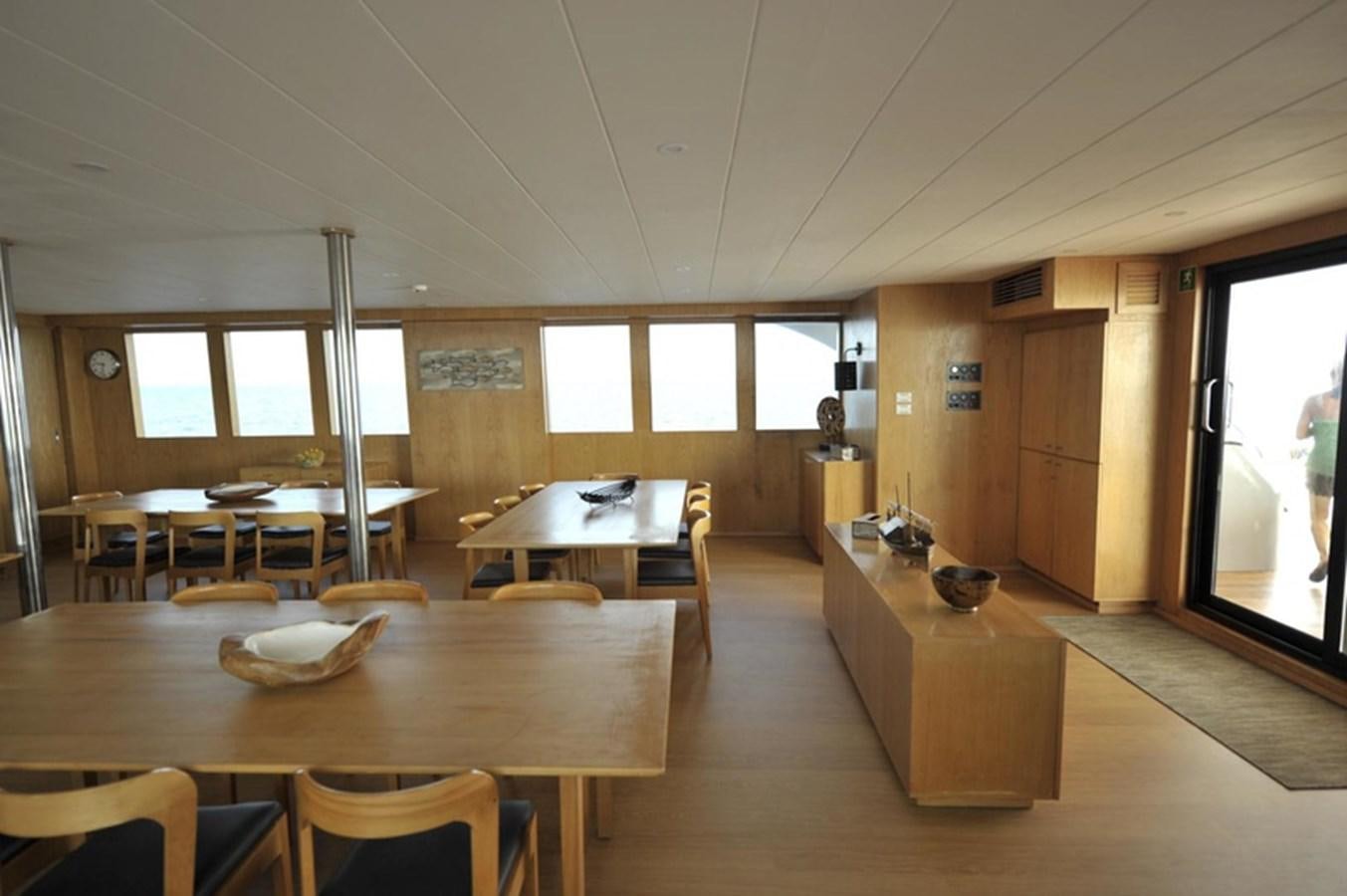 a room with tables and chairs aboard 2017 SAFARI  142 CUSTOM Yacht for Sale